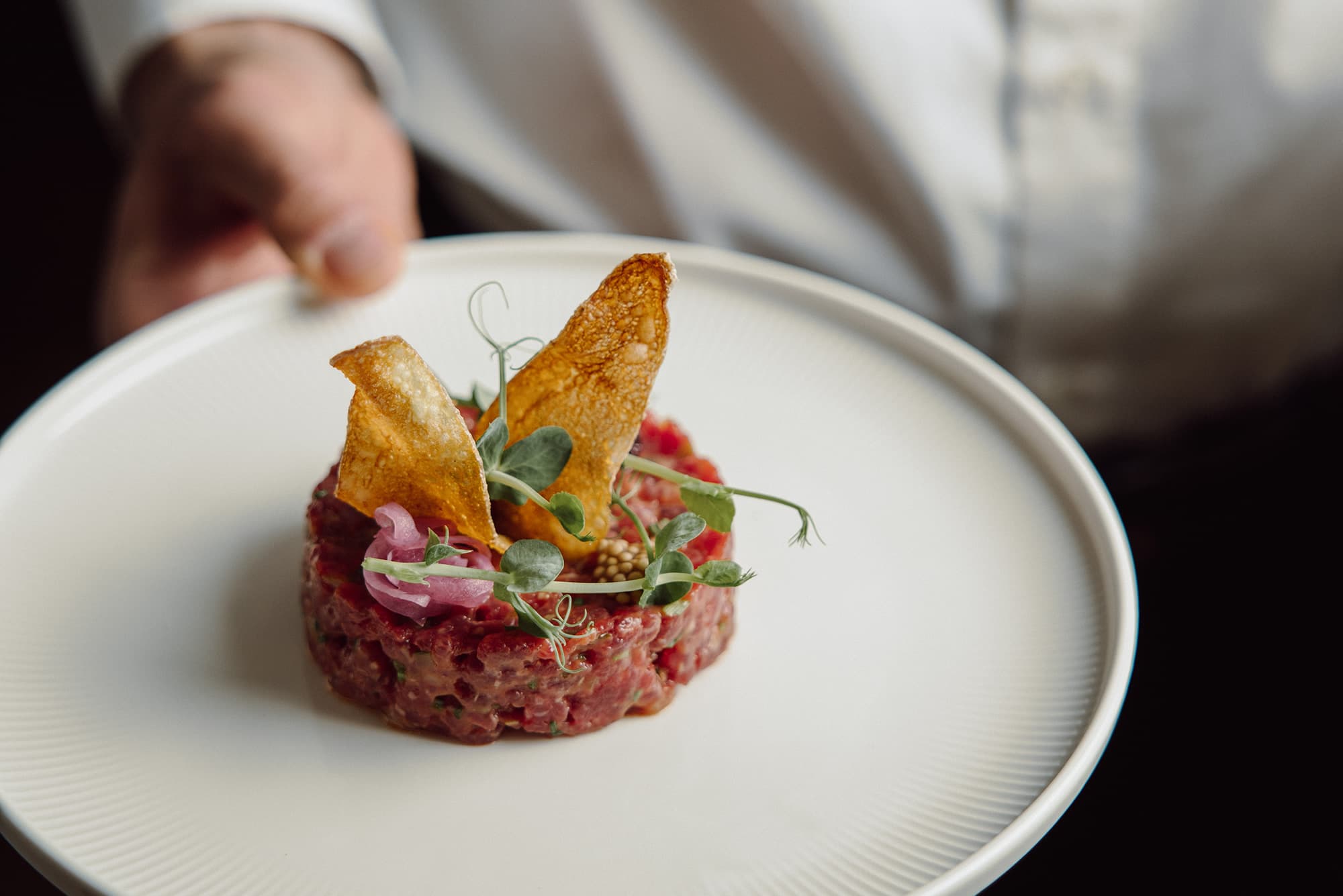 Signature dish Beef Tatar, garnished with chips and herbs from chef Joseph Oberreiter