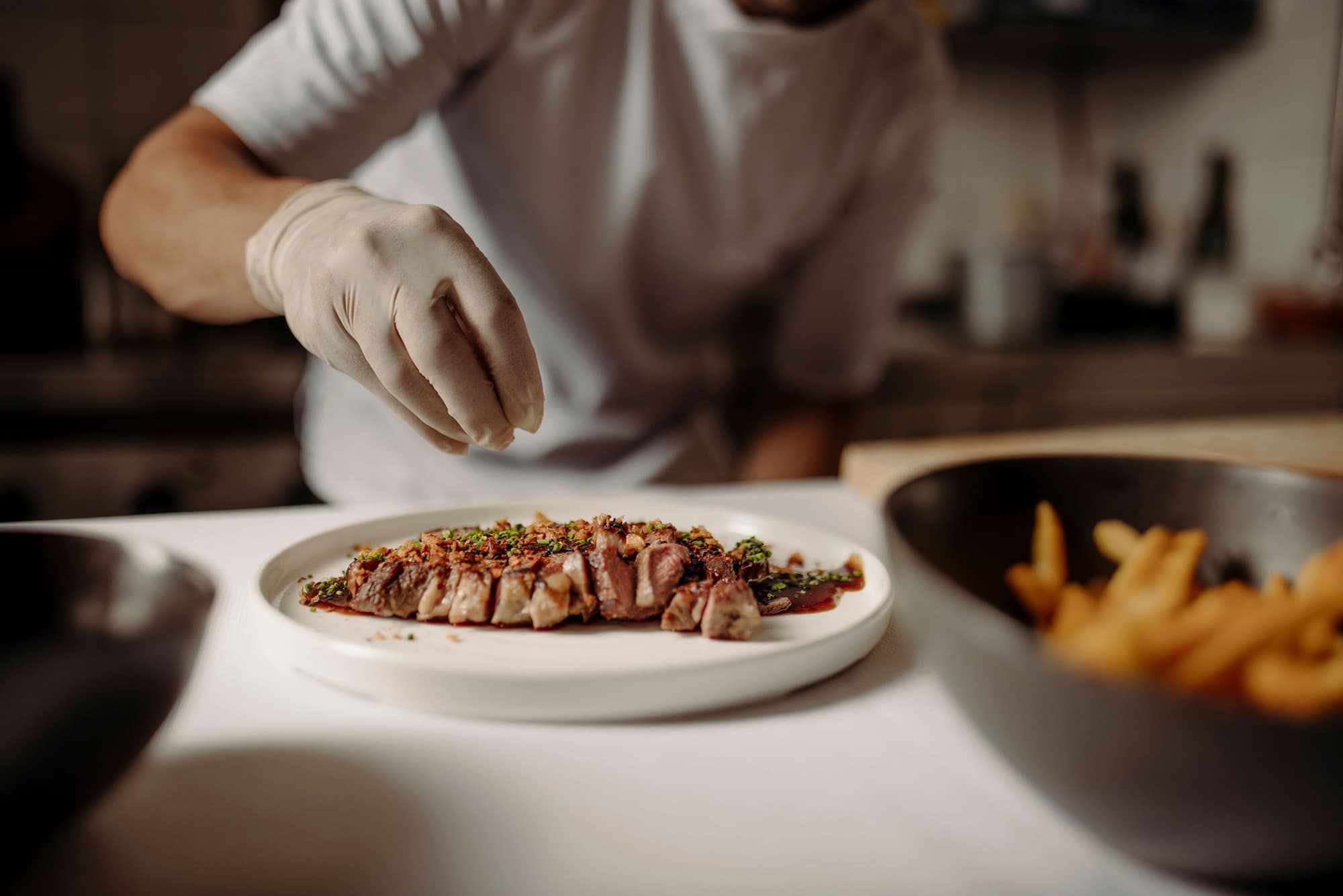 Preparing a dish ready to serve in the Restaurant seven's kitchen in Flachau